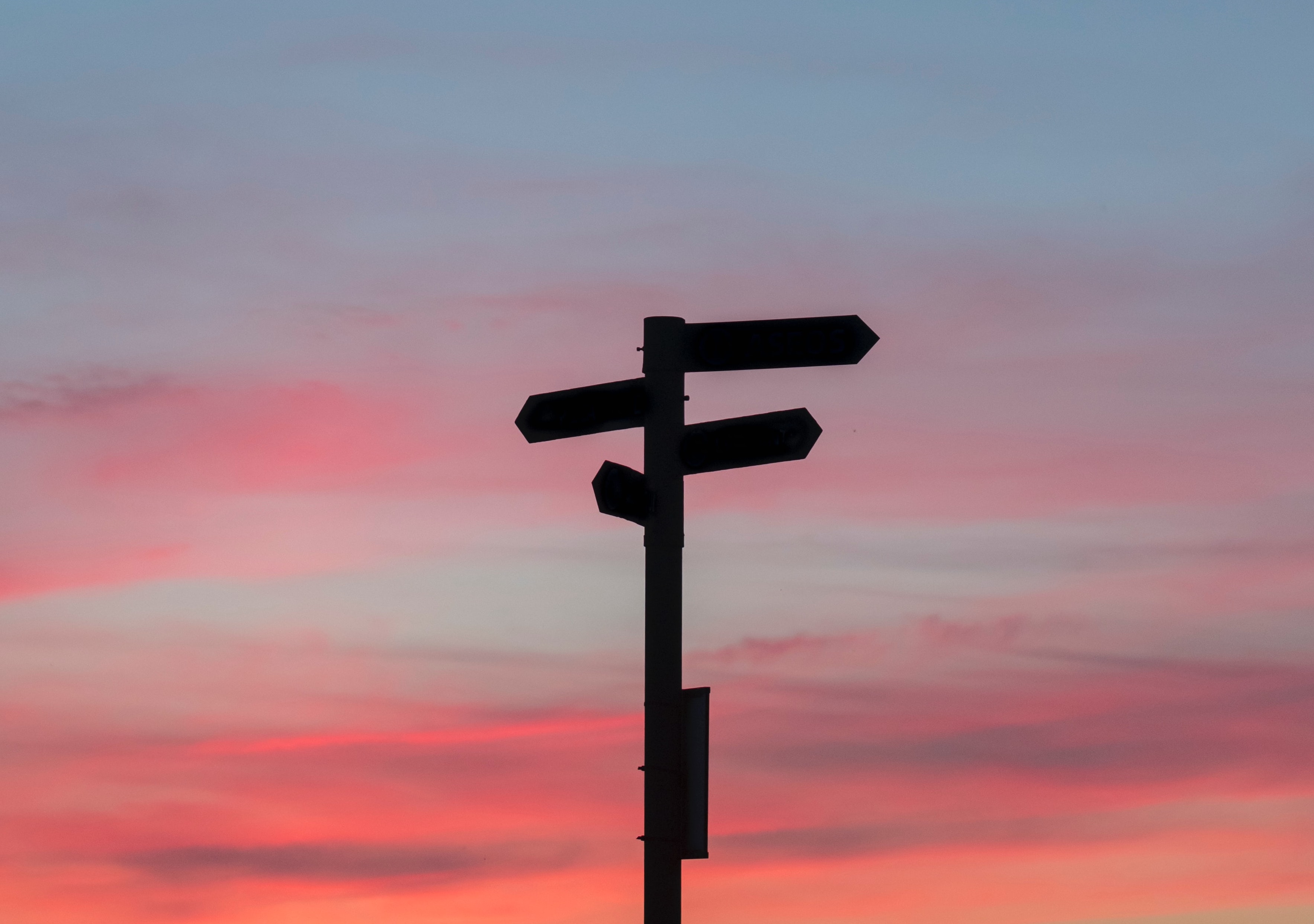 Bewegwijzeringspaal, gekleurde lucht zonsondergang